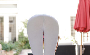 Well-shaped gal pulls yoga pants down to show hair-lined cunt while stretching