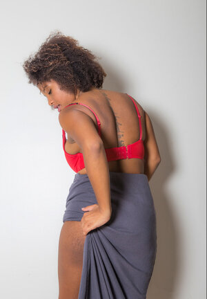 Chesty dark-skinned sweetie touches her large naked breasts for the camera