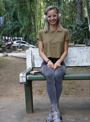 Veronica Leal poses on hood in green shirt & tight jeans