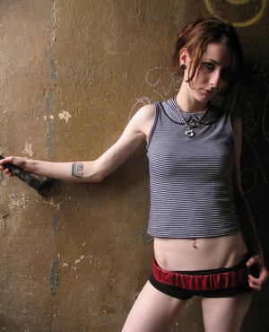 Slender brunette strips and fondles her tiny tits while posing naked